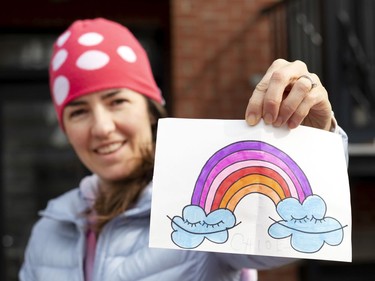 Vanessa Guilbeault-Houde displays a 'Ça va bien aller' rainbow made with her daughter, Laura Hebert, 2, and her son Louis, 7, as they deliver rainbows to homes on March 25, 2020.