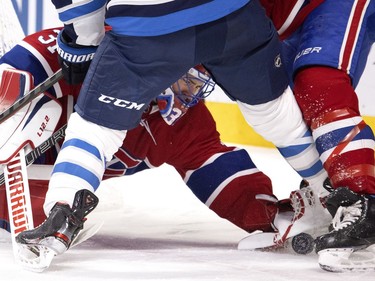 Canadiens goaltender Carey Price reaches between legs to cover the puck during NHL action in Montreal on Saturday, March 6, 2021.