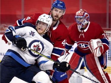 Winnipeg Jets' Andrew Copp (9) leans into Canadiens defenceman Joel Edmundson (44) as Montreal goaltender Carey Price follows the play during NHL action in Montreal on Saturday, March 6, 2021.