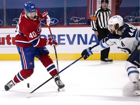 Winnipeg Jets defenceman Josh Morrissey (44) knocks the puck away from Canadiens' Joel Armia (40) during NHL action in Montreal on Saturday, March 6, 2021.