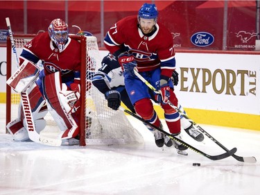 Canadiens defenceman Brett Kulak (77) is pressured by Winnipeg Jets' Nate Thompson (11) as Montreal goaltender Carey Price looks on during NHL action in Montreal on Saturday, March 6, 2021.