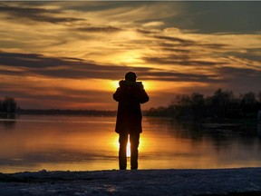 A man stops to photograph the sunset on Lac St-Louis in the Lachine borough of Montreal Tuesday, March 16, 2021.
