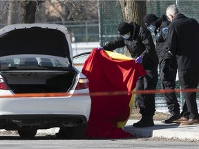 Police at the scene where a man and a woman were found dead inside a taxi in St-Léonard on Friday, March 19, 2021.