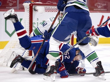 Canadiens' Artturi Lehkonen (62) gets dumped in front of Vancouver Canucks goaltender Braden Holtby (49) during NHL action in Montreal on Saturday, March 20, 2021.
