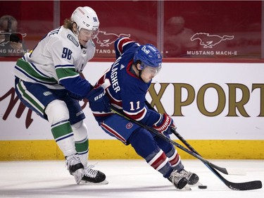 Vancouver Canucks centre Adam Gaudette (96) nudges Montreal Canadiens' Brendan Gallagher (11) off the puck during NHL action in Montreal on Saturday, March 20, 2021.