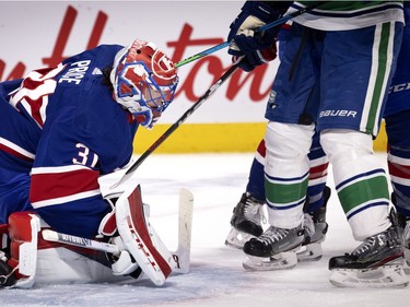 Canadiens goaltender Carey Price (31) tries to peek through six legs during NHL action against the Vancouver Canucks in Montreal on Saturday, March 20, 2021.