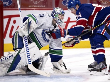 Canadiens' Corey Perry (94) holds on to Vancouver Canucks goaltender Braden Holtby after Holtby covered the puck with his glove during NHL action in Montreal on Saturday, March 20, 2021.