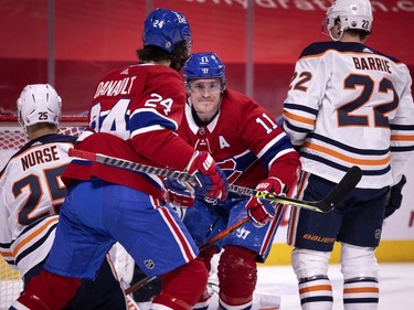 Montreal Canadiens right winger Brendan Gallagher (11) smiles at Montreal Canadiens centre Phillip Danault (24) after scoring the third goal against Edmonton Oilers goaltender Mikko Koskinen (19) during NHL action in Montreal on Tuesday, March 30, 2021.