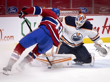 Montreal Canadiens defenseman Brett Kulak (77) tries to stuff the puck past Edmonton Oilers goaltender Mikko Koskinen (19) during NHL action in Montreal on Tuesday, March 30, 2021.