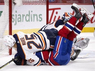Edmonton Oilers defenseman Darnell Nurse (25) knocks Montreal Canadiens left wing Artturi Lehkonen (62) to the ice and holds him down during NHL action in Montreal on Tuesday, March 30, 2021.