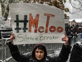 People carry signs addressing the issue of sexual harassment at a #MeToo rally outside of Trump International Hotel on Dec. 9, 2017 in New York City.