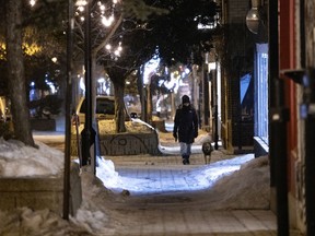 MONTREAL, QUE.: March 2, 2021 -- A woman walks her dog on Duluth Ave. after curfew in Montreal, on Tuesday, March 2, 2021. (Allen McInnis / MONTREAL GAZETTE) ORG XMIT: 65