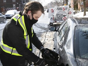 Ryan Chadwick-Chabot, co-owner of Fuel It, puts gas in a car in NDG on Wednesday March 3, 2021 during the COVID-19 pandemic. Fuel It is a subscription-based local company where its owners come and gas up your car so you don't have to go to the gas station.