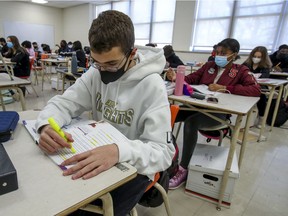 Students work at their desks at Montreal's John F. Kennedy High School in November. Government officials have said the threat to the mental health of students outweighs the risks of contracting COVID-19. Despite the spread of more contagious COVID-19 variants, Premier François Legault announced on Tuesday that all Grade 9, 10 and 11 students would attend school full time in COVID-19 red zones, starting on Monday.