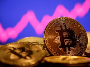 A representation of virtual currency Bitcoin is seen in front of a stock graph in this illustration taken January 8, 2021.