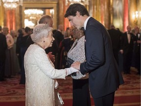 Britain's Queen Elizabeth II greets Canada's Prime Minister Justin Trudeau (R) in the Blue Drawing Room during a drinks reception before The Queen's Dinner during The Commonwealth Heads of Government Meeting (CHOGM), at Buckingham Palace in London on April 19, 2018.  Britain's Queen Elizabeth II, accompanied by Britain's Prince Charles, Prince of Wales, will receive Commonwealth Heads of Government and their spouses in the Blue Drawing Room, where the evening commences with a drinks reception. The dinner will take place in the Picture Gallery where Her Majesty will give a speech.