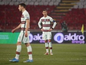 Portugal's forward Cristiano Ronaldo, right, reacts at the end of the FIFA World Cup Qatar 2022 qualification Group A football match between Serbia and Portugal in Belgrade March 27, 2021.