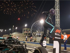 Mercedes' British driver Lewis Hamilton celebrates after winning the Bahrain Formula One Grand Prix at the Bahrain International Circuit in the city of Sakhir on March 28, 2021.