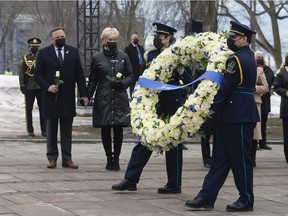Health workers carry a wreath as Quebec Premier Francois Legault, left, and his wife Isabelle Brais look on during a ceremony for the victims of COVID-19, Thursday, March 11, 2021 at the legislature in Quebec City.