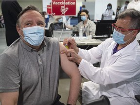 Premier François Legault receives his COVID-19 vaccination in Montreal, Friday, March 26, 2021. Given the increase in cases this week, Legault says he will re-evaluate the recent loosening of measures in the province early next week.