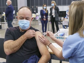 Quebec Health Minister Christian Dubé receives the AstraZeneca Covishield vaccine at a COVID-19 vaccination clinic in Montreal on March 18, 2021.