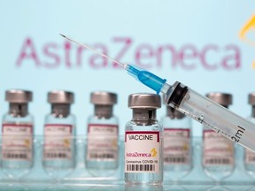 Vials labelled "AstraZeneca COVID-19 Coronavirus Vaccine" and a syringe in front of an AstraZeneca logo.