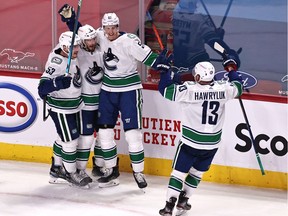 Vancouver Canucks players celebrate after J.T. Miller scored in overtime to beat the Canadiens 3-2 Friday night at the Bell Centre.