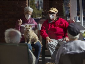 Eva and Myron Echenberg chat with Judy and Michael Rasminsky in Westmount. Perry is the Echenberg's dog.