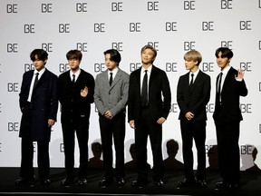 Members of K-pop boy band BTS pose for photographs during a news conference promoting their new album "BE(Deluxe Edition)" in Seoul, South Korea, November 20, 2020.