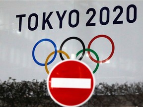The logo of Tokyo 2020 Olympic Games that have been postponed to 2021 because of the coronavirus disease (COVID-19) outbreak, is seen through a traffic sign at Tokyo Metropolitan Government Office building in Tokyo on Jan. 22, 2021.