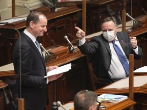 Quebec Premier François Legault gestures at Eric Girard as the finance minister presents his budget in the legislature in Quebec City, Thursday, March 25, 2021.