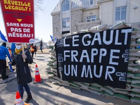 Public-sector workers build a wall to symbolize stalled contract negotiations during a protest in front of Premier François Legault's riding office Wednesday, March 17, 2021 in L'Assomption.