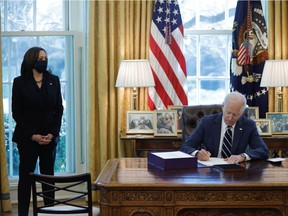 U.S. President Joe Biden signs the American Rescue Plan, a package of economic relief measures to respond to the impact of the coronavirus disease (COVID-19) pandemic, inside the Oval Office at the White House in Washington, U.S., March 11, 2021.