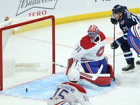 Winnipeg Jets forward Paul Stastny, centre top, is unable to get to a loose puck behind Montreal Canadiens goaltender Carey Price in Winnipeg on March 15, 2021.