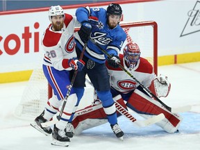 Canadiens defenceman Jeff Petry and Jets centre Pierre-Luc Dubois battle for position in front of goalie Carey Price during game Wednesday night.