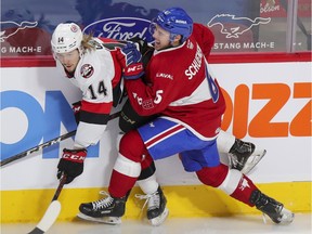Laval Rocket defenceman Corey Schueneman grimaces while checking Belleville Senators Filip Chlapik during first period of American Hockey League game in Montreal on Feb. 12, 2021.