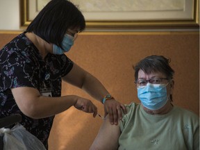 Gloria Lallouz, a resident of the Donald Berman Maimonides Geriatric Centre in Côte-St-Luc, receives her second dose of the COVID-19 vaccine Tuesday, March 9, 2021 from Registered Nurse Dahlia Villariez. Lallouz is one of only a few people to get a second dose of a COVID-19 vaccine. Other long-term care residents have to wait until four months after their first dose.