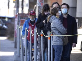 Mostly masked and respecting two meter distance, a line builds outside the Parc Ave Covid-19 testing site, in Montreal, on Tuesday, April 6, 2021. (Allen McInnis / MONTREAL GAZETTE) ORG XMIT: 65979