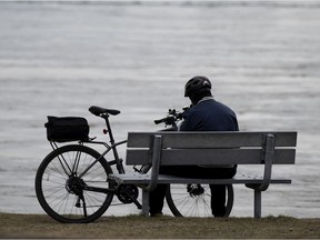 A man enjoys a quiet moment along the shore of Lac St. Louis on Wednesday.
