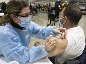 Nurse Nadine Landry injects Mitch Garber with the AstraZeneca Vaccine on Thursday April 8, 2021 at the Bill Durnan arena.