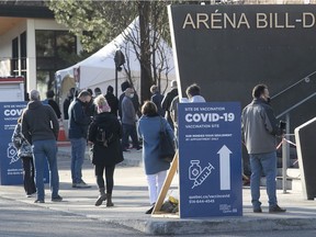 Montrealers wait outside the Bill Durnan arena on Thursday April 8, 2021 for their AstraZeneca vaccine.