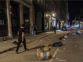 A man walks on Notre-Dame St. in Old Montreal on Sunday, April 11, 2021. A crowd of at least several hundred people had gathered at the Old Port, chanting, setting off fireworks and causing damage to protest the return to an 8 p.m. curfew.