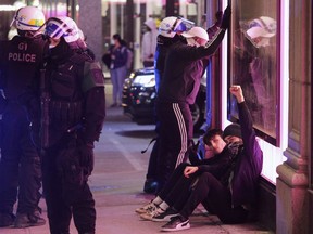 Young men are detained by Montreal police in downtown Montreal Monday, April 12, 2021. People protesting against COVID-19 restrictions set by the Quebec government were out after the 8 p.m. curfew.