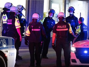 Montreal police stop and speak to people on Ste-Catherine St. after curfew in Montreal on Sunday, April 11, 2021.