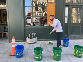 Restaurant co-owner Rob Stutman cleans up on April 12, 2021, following the previous night's anti-curfew riots in Old Montreal.