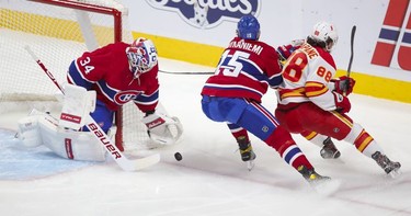 Habs goalie Jake Allen makes a save on shot by Calgary Flamess Andrew Mangiapane as Jesperi Kotkaniemi backchecks during first period at the Bell Centre in Montreal on Wednesday April 14, 2021.
