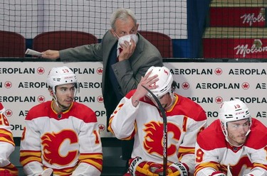 Calgary Flames head coach Darryl Sutter watches his team play during third period at the Bell Centre in Montreal on Wednesday, April 14, 2021.  In front of Sutter: Johnny Gaudreau, left, Sean Monahan and Matthew Tkachuk.