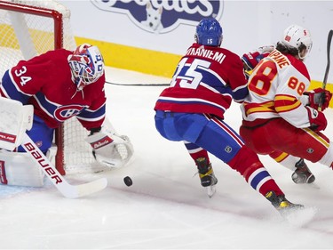 Habs goalie Jake Allen makes a save on shot by Calgary Flamess Andrew Mangiapane as Jesperi Kotkaniemi backchecks during first period at the Bell Centre in Montreal on Wednesday April 14, 2021.