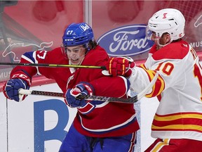 Canadiens defenceman Alexander Romanov Battles Flames' Mikael Backlund during second period Wednesday night at the Bell Centre.