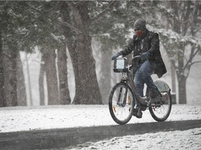 A Bixi cyclist makes his way along the snowy paths of Lafontaine park during afternoon snowfall in Montreal on Wednesday April 21, 2021.